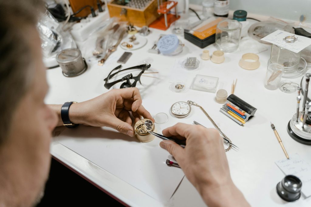 A skilled watchmaker meticulously repairs a vintage watch in a workshop setting.